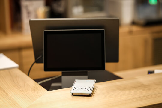 Modern reception desk with contactless access scanner and computer screen, representing smart technology in business, hospitality, or office environments.