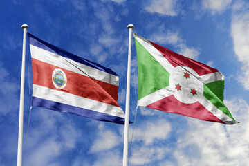 3D illustration. Costa Rica and Burundi flags waving in the sky. High detailed waving flag. 3D...
