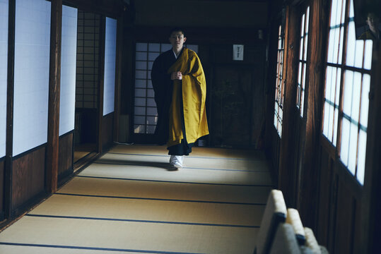 伝統的な日本寺院の廊下を歩く僧侶