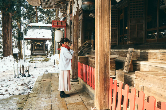 神社でお参りをする日本人女性