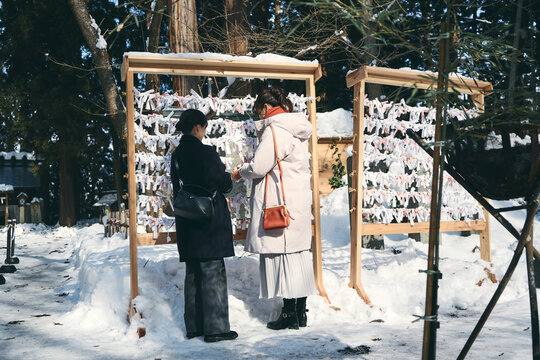 神社でおみくじを結ぶ日本人女性
