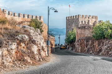 Ancient stone walls and watchtower at Alanya Castle overlooking the sea and coastal town. The...