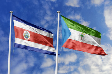 3D illustration. Costa Rica and Equatorial Guinea flags waving in the sky. High detailed waving flag. 3D render. Flags fluttered in the cloudy sky, symbolizing diplomatic relations.