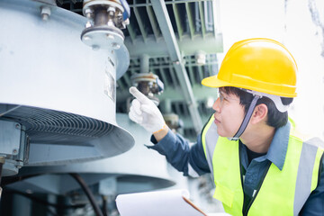 Engineer is working at high voltage power substation performing inspection and check of...