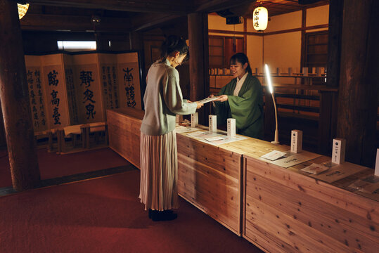 神社でお札を受け取る日本人女性