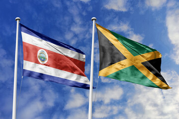 Waving flags of Costa Rica and Jamaica against a vibrant blue sky, symbolizing international...