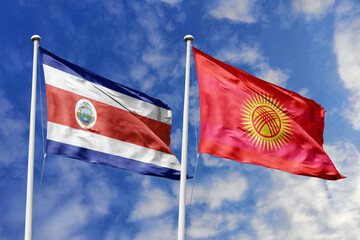 Two flags, the national flag of Costa Rica and the national flag of Kyrgyzstan, waving side by side against a blue sky with clouds, symbolizing international relations and diplomacy.