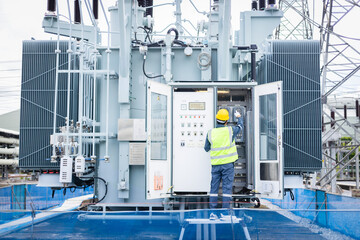 Engineer is working on high voltage power substation performing inspection and check of infrastructure to ensure safety and proper operation of electrical system