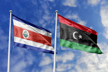 Costa Rica and Libya flags proudly waving against a vibrant blue sky, symbolizing international relations, friendship, and diplomacy between the two nations.