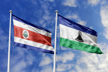 Costa Rica and Lesotho flags proudly waving against a vibrant blue sky, symbolizing international...