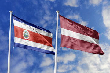 Costa Rica and Latvia flags proudly waving against a vibrant blue sky, symbolizing international...