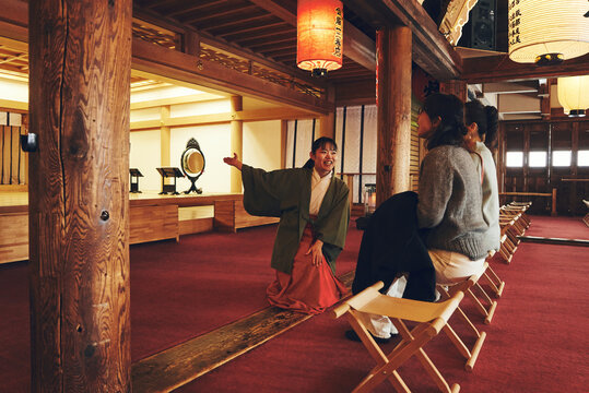 巫女さんに神社の案内をしてもらう日本人女性