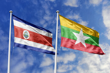 Costa Rica and Myanmar flags proudly waving against a vibrant blue sky, symbolizing international...