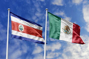 Costa Rica and Mexico flags proudly waving against a vibrant blue sky, symbolizing international...
