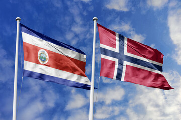 Costa Rica and Norway flags proudly waving against a vibrant blue sky, symbolizing international relations, friendship, and diplomacy between the two nations.