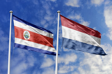 Costa Rica and Netherlands flags proudly waving against a vibrant blue sky, symbolizing...