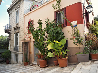 Naklejka premium Mediterranean home exterior with abundant potted greenery and rustic charm.