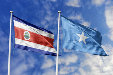 Costa Rica and Somalia National Flags Waving Together Against a Vivid Blue Sky, Symbolizing International Relations and Global Diplomatic Efforts.