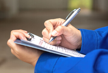 A construction foreman is checking on building quality checklist report during inspecting at the...