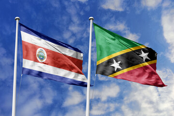 Costa Rica and Saint Kitts and Nevis National Flags Fluttering Together Under a Bright Blue Sky,...