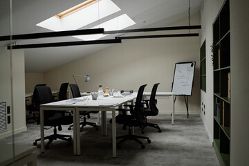 Empty modern office workspace featuring several desks with scattered documents and office supplies,...