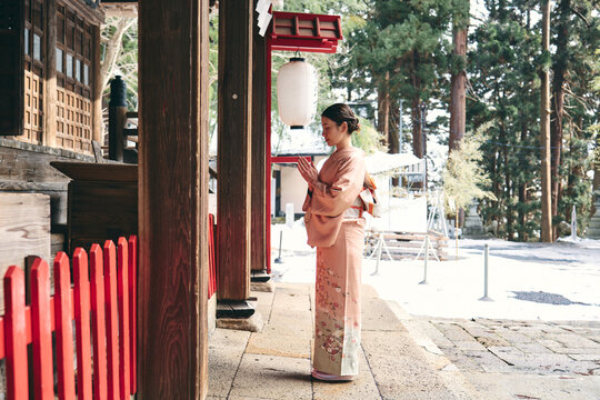 神社にお参りをする着物姿の日本人女性
