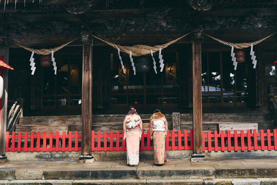 神社にお参りをする着物姿の日本人女性
