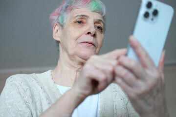 I see no good reason to act my age. A cheerful elderly woman with multi-colored hair using...