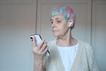 I see no good reason to act my age. A cheerful elderly woman with multi-colored hair listening...