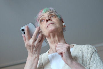 I see no good reason to act my age. A cheerful elderly woman with multi-colored hair listening...