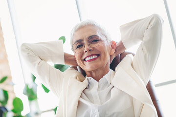 Smiling mature businesswoman in a professional office environment wearing elegant formal attire,...
