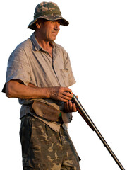 A hunter with a gun in his hands in hunting clothes in the autumn forest in search of a trophy. A...