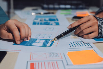 Group of young application developers analyzing uxui mobile app templates during a working meeting