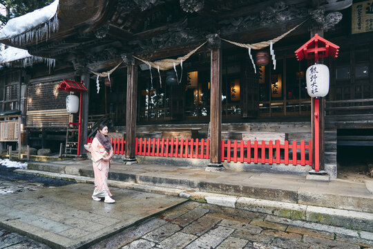 冬の神社でお詣りをする日本人女性