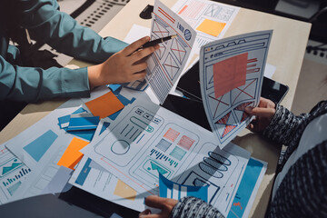 Group of young application developers analyzing uxui mobile app templates during a working meeting