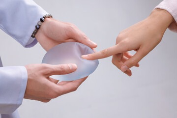 Patient and Surgeon Demonstrate Silicone Breast Implant for Mammoplasty and Augmentation Procedure