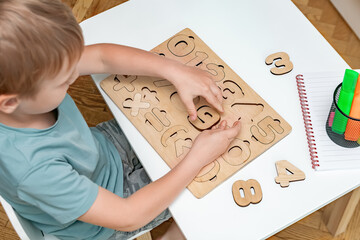 Child boy playing with wooden mosaic board.Kid learning numbers,counting math.Children logic,early...