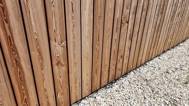 boarded lot with a palisade at the bottom. the top of the fence is jagged from boards like an unfinished fence. the sloppy look is intentional