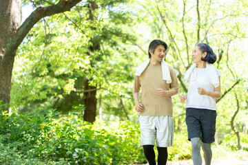 公園をジョギングするミドル夫婦