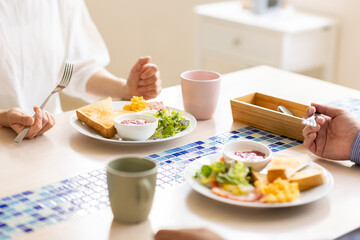 朝食を食べる夫婦の手元