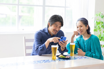 ビールを飲みながらスマホを見る男女