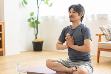 自宅でヨガをする男性