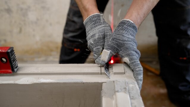 Skilled worker using laser level and measuring tools on construction site