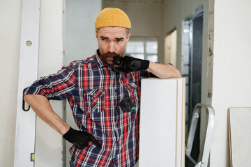 construction worker guy with a drill on a white wall background.master for an hour. construction worker guy with a drill on a white wall background.master for an hour. laying laminate flooring in an a