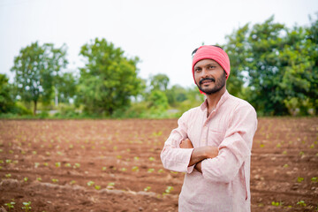 young indian farmer standing at field