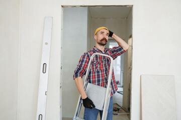 construction worker guy with a drill on a white wall background.master for an hour.