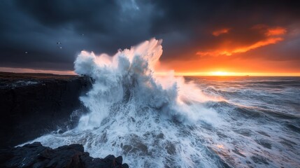 Fototapeta premium A stunning natural scene depicts a powerful ocean wave crashing against rocky cliffs during a dramatic sunset, creating an awe-inspiring moment in nature.