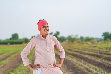 Young indian farmer standing at agriculture field