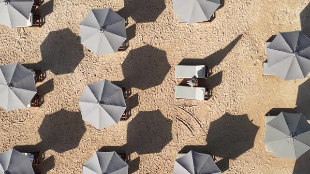 Top-down aerial video of beach umbrellas at white sand beach at sunny day. Nusa Dua. Bali.Indonesia