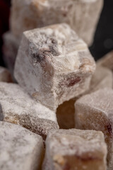 Turkish delight with cherry on a slate close up, cubes of sweet Turkish delight with the addition of dried red berries in powdered sugar